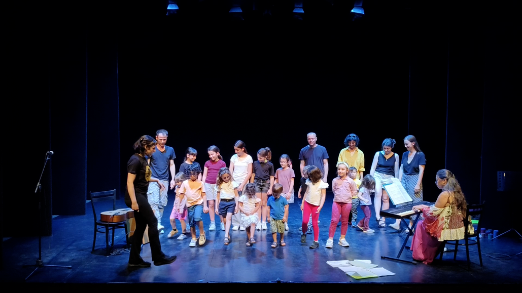 Gruppo di bambini che canta su un piccolo palco